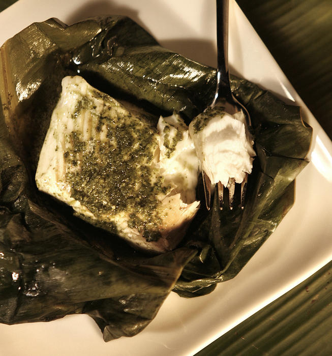 Grilled halibut with cilantro-lime sauce in banana leaves