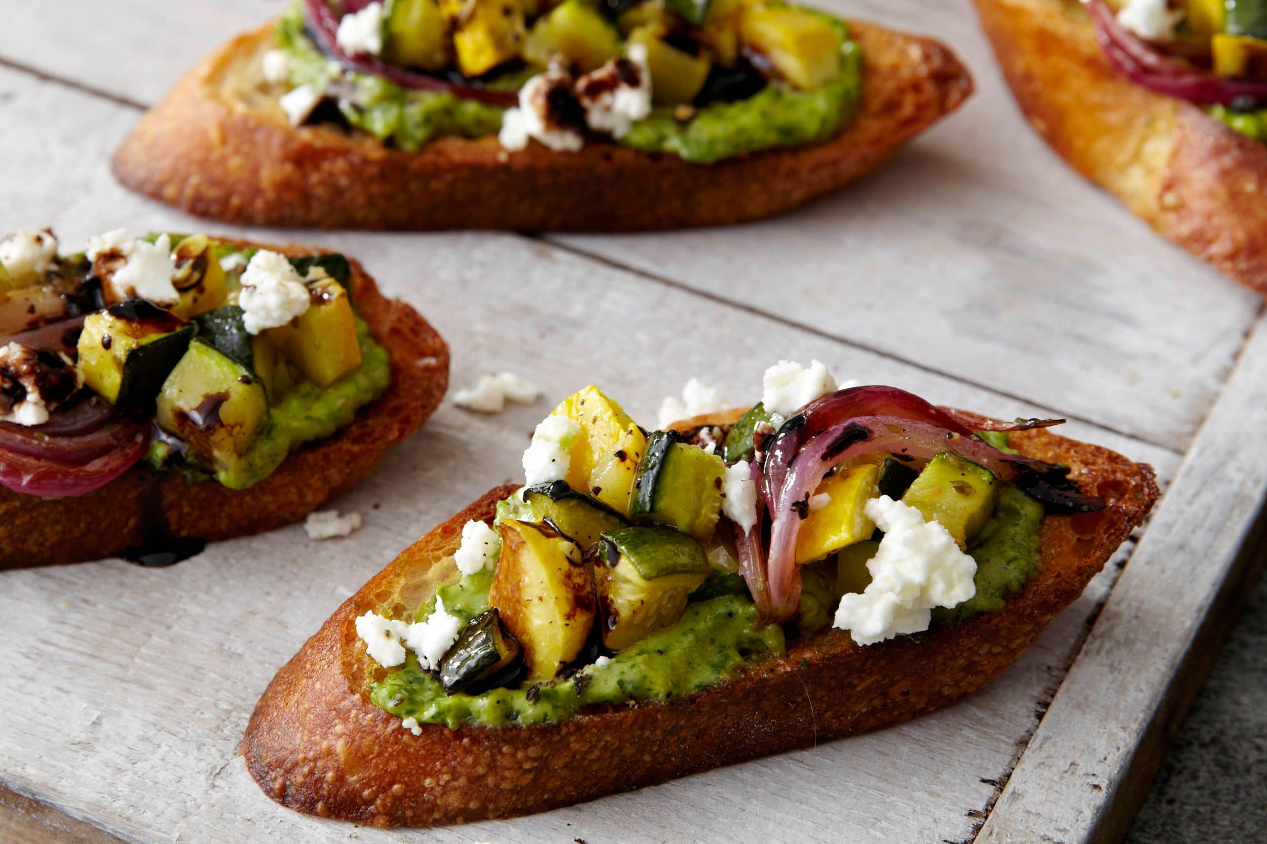 Roasted Veggie Crostini with Sunflower Seed-Cream Cheese Pesto